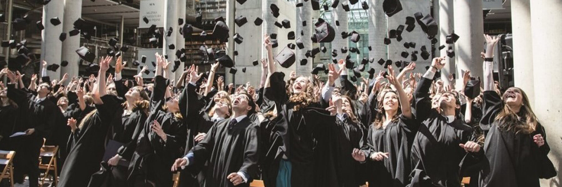 a class of graduates throwing their graduation hats into the air to celebrate